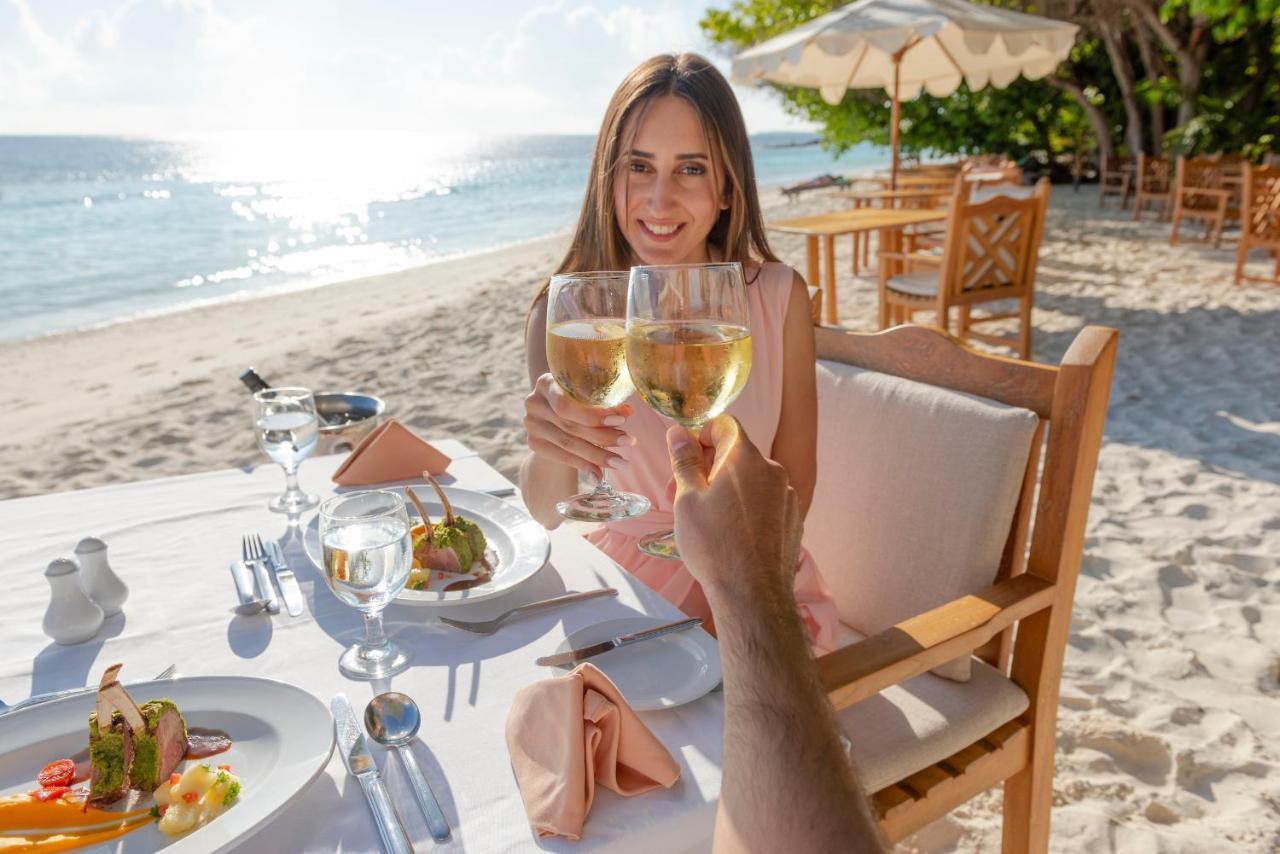 Royal Island Resort Maldives Dharavandhoo Esterno foto A woman dining on a beach